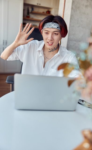 Asian guy waving by his hand while chatting online