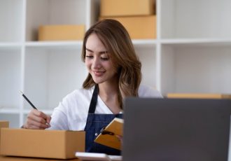 Portrait of Asian young woman SME working with a box at home the workplace.start-up small business